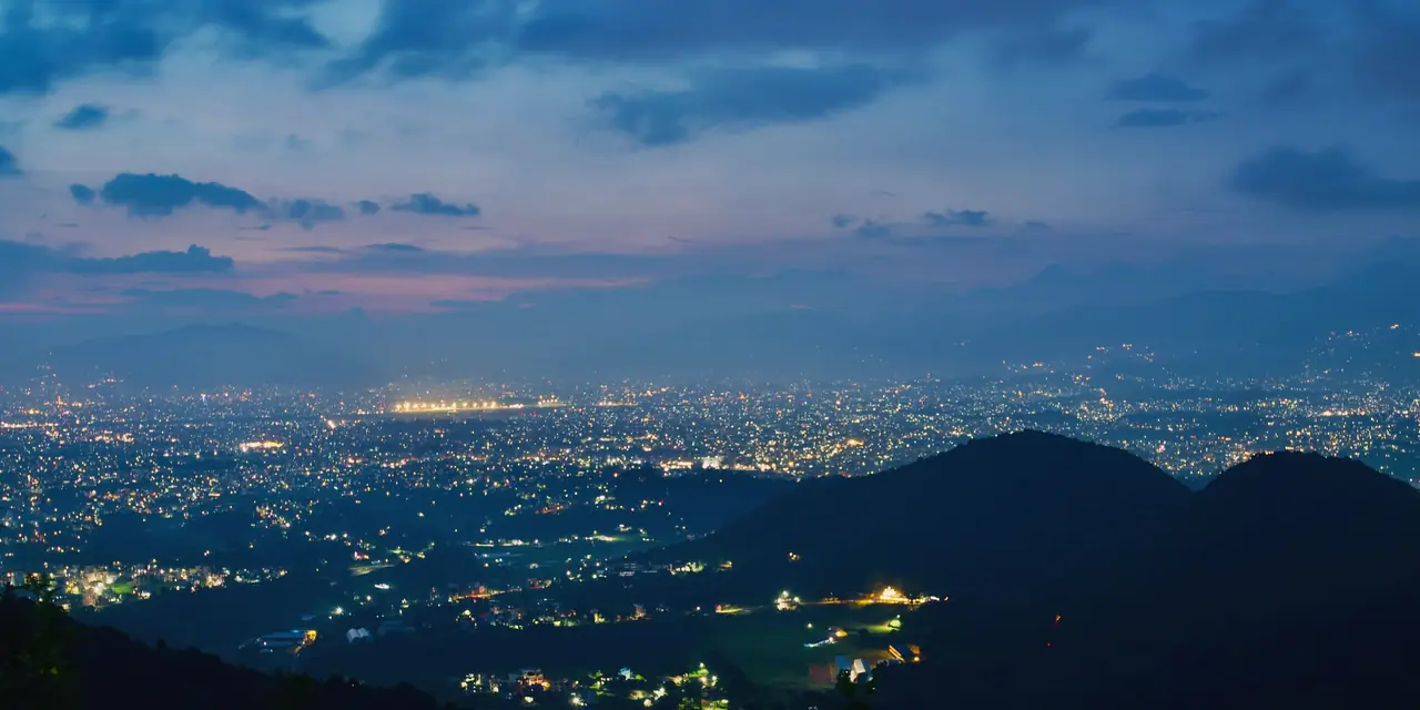 Example frame: a city’s lights at twilight seen from a hill