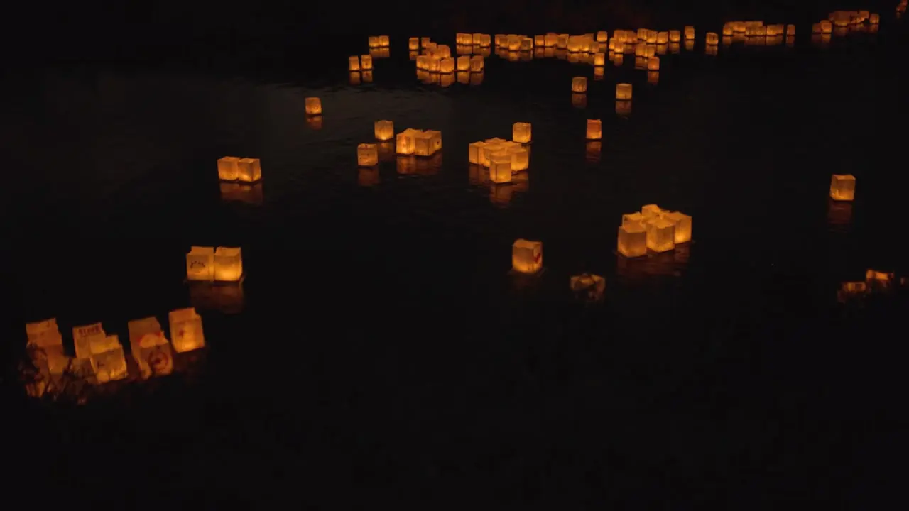 Example frame: paper lanterns floating on dark water at night